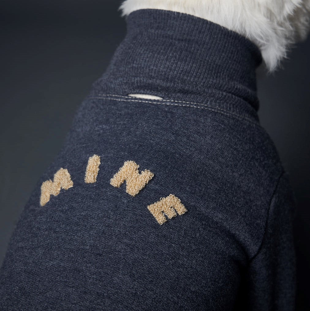 Basic blue heather fleece turtleneck sweater with ribbed details and MINE in sand color embroidery on the back