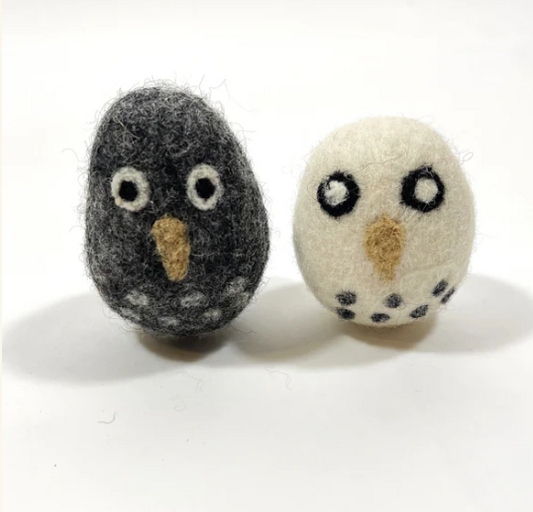 Two felted owl figurines, one gray and one white, on a white background