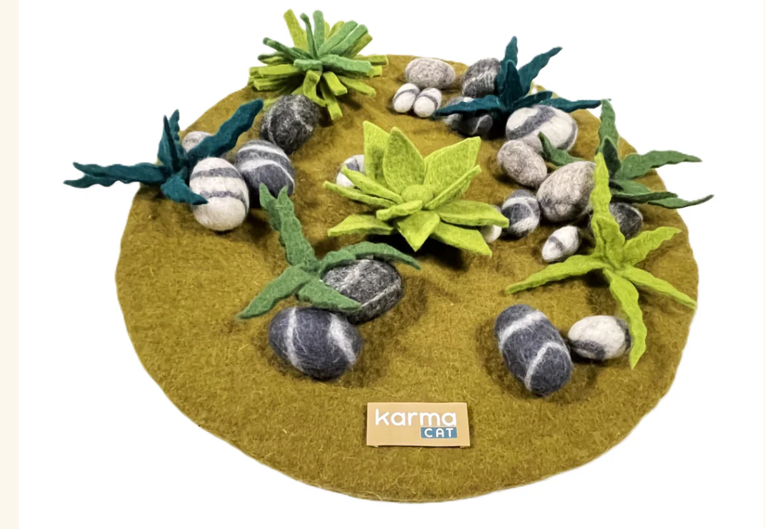 Felted cat toy with plants and stones on a green felt base, featuring the Karma Cat brand.